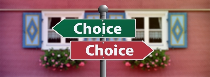 Two signs on single signpost with word 'choice' point in opposite directions at a crossroads before a big decision